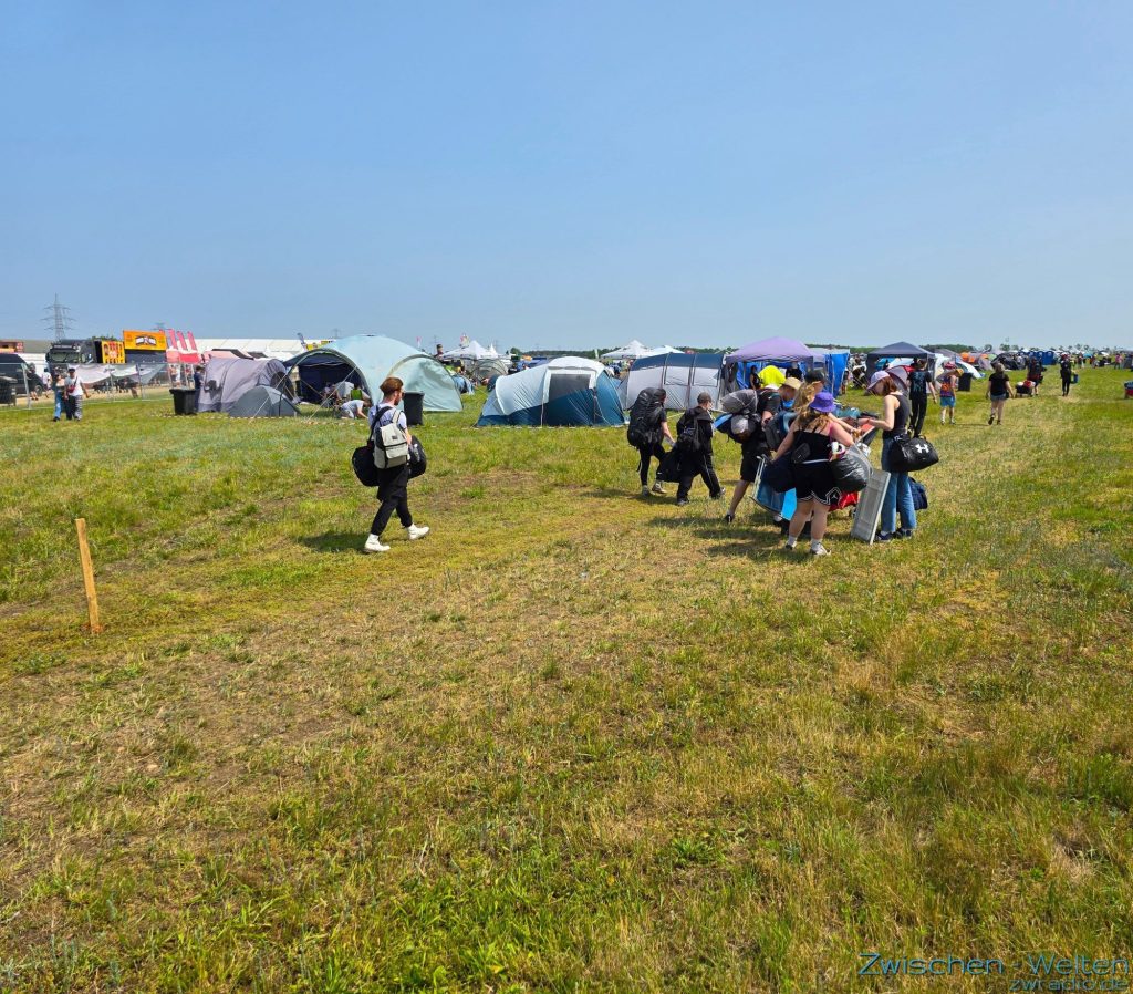 Besucher laufen über das Camping-Gelände